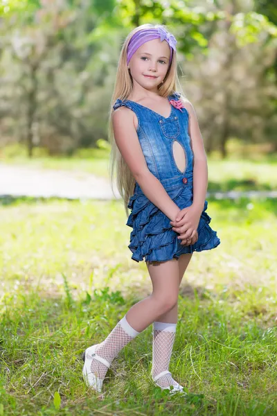 Liten blond tjej i jeans klänning — Stockfoto