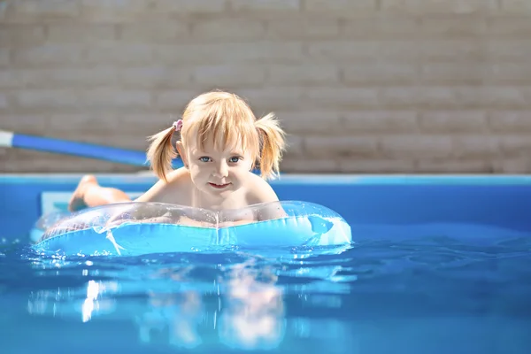 Piccola ragazza bionda in piscina d'acqua — Foto Stock