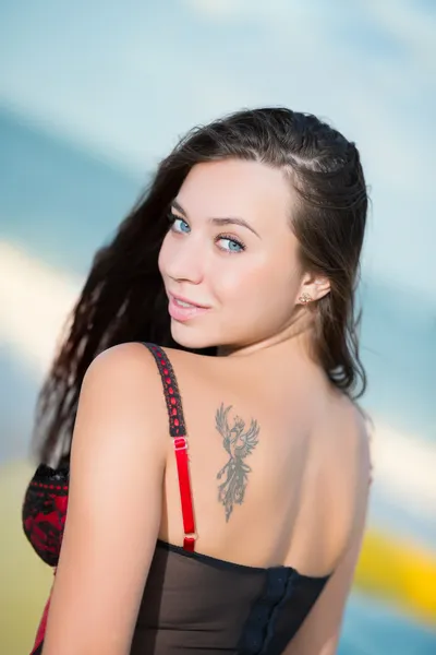 Sexy brunette die zich voordeed op het strand — Stockfoto