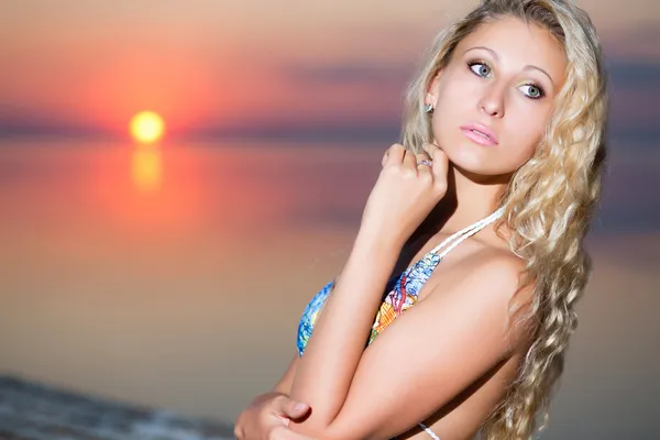 Lächelnde blonde Frau posiert bei Sonnenuntergang — Stockfoto