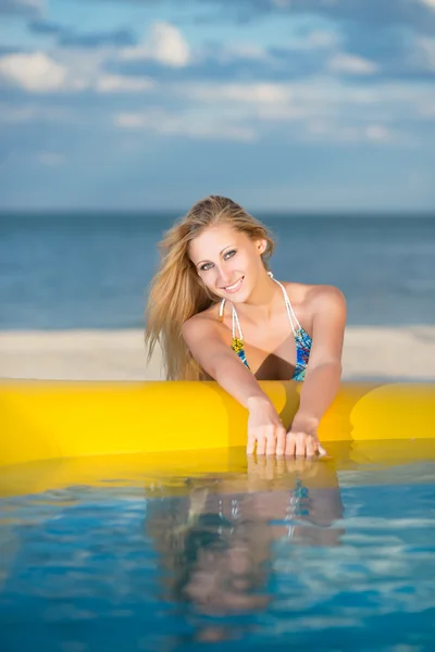 Sexy rubia posando cerca de la piscina amarilla — Foto de Stock
