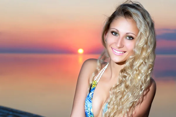 Lachende blonde vrouw die zich voordeed bij de zonsondergang — Stockfoto