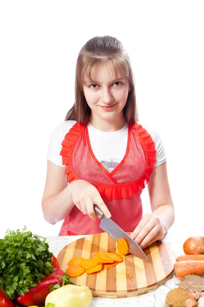 Teenager chef cook cuts carrots — Stock Photo, Image