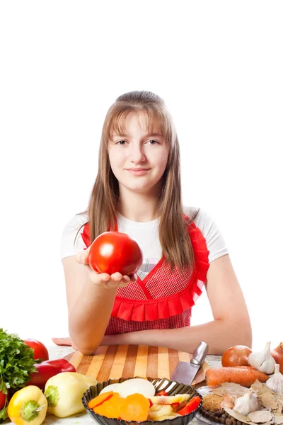 Girl the cook offers a tomato — Stock Photo, Image
