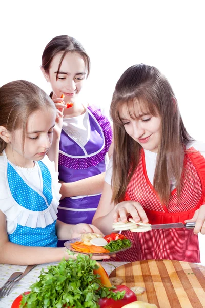 Tre ragazze del cuoco preparano un piatto vegetariano — Foto Stock