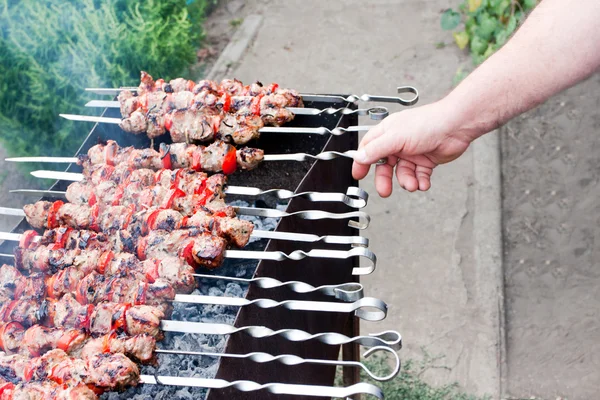 Man fries a shish kebab on a barbecue — Stockfoto