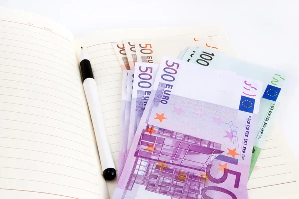 Billetes en euros, cuaderno y bolígrafo —  Fotos de Stock