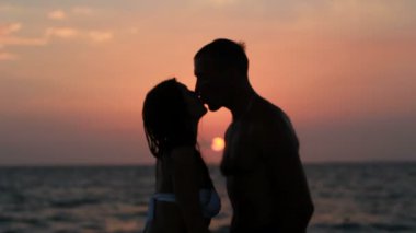 Sahilde iki siluet. günbatımı ışığı.