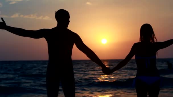 Силует пара на пляжі. під час заходу сонця світла. — стокове відео