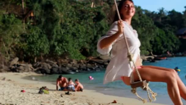 Femme à la plage est assis sur une balançoire — Video