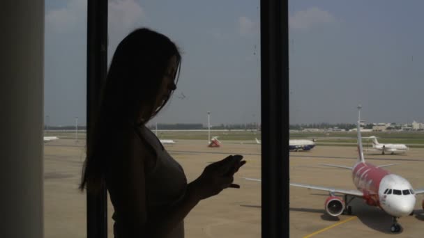 Girl speaks by a mobile phone at the airport — Stock Video