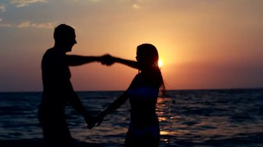 Sahilde iki siluet. günbatımı ışığı.