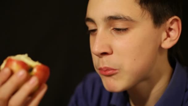 Мальчик ест яблоко — стоковое видео