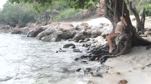 Vrouw aan het strand bevindt zich op een schommel — Stockvideo