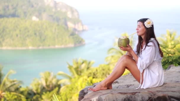 Jonge vrouw met coco op het strand — Stockvideo