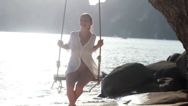 Vrouw aan het strand bevindt zich op een schommel — Stockvideo