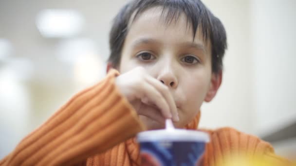 Хлопчик п'є соду або тремтить від соломи — стокове відео