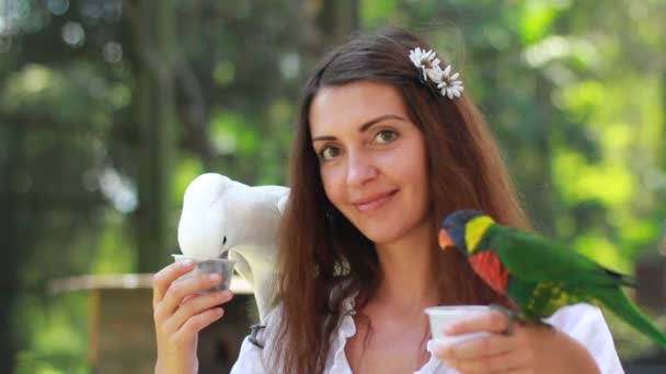 Menina sorridente com papagaio colorido na selva — Vídeo de Stock