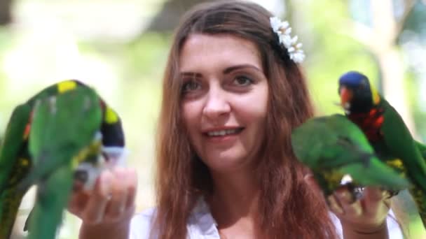 Smiling girl with colorful parrot in the jungle