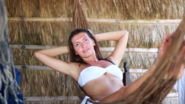 Hermosa mujer joven acostada en una hamaca — Vídeos de Stock