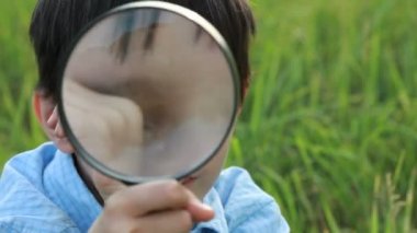 çocukla Büyüteç çim üzerinde yalan