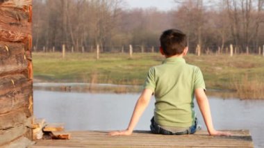Evin verandada oturan çocuk. Nisan
