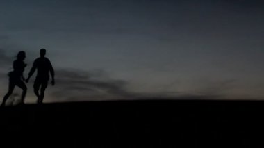 rahat genç pasionate çift balayında turuncu arka plan ile bir çölde günbatımı güzellik zevk