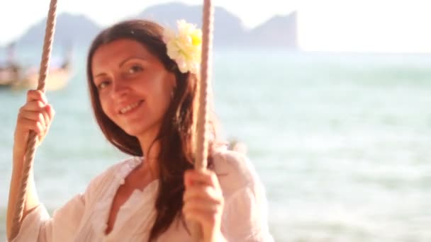 Vrouw aan het strand bevindt zich op een schommel — Stockvideo