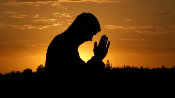 Man doet yoga oefeningen in een veld bij zonsopgang — Stockvideo