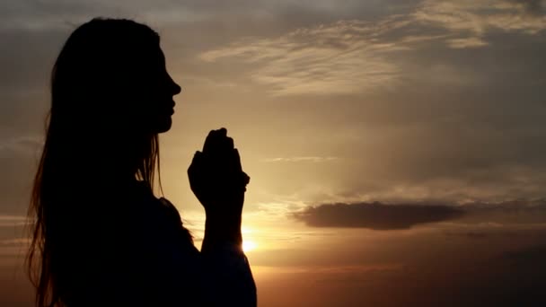 Rugăciune. Femeie cu mâinile pliate la mare în timpul apusului de soare . — Videoclip de stoc