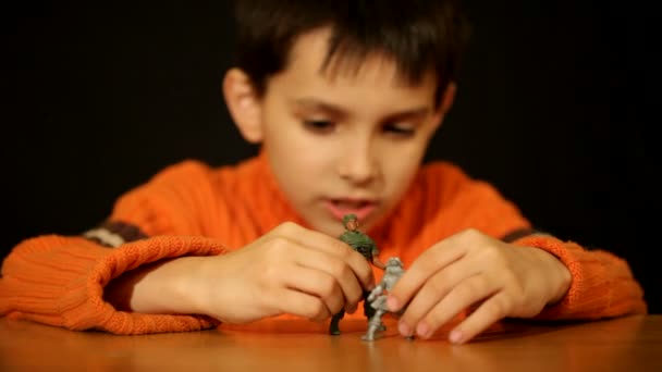 Niño jugando juguete soldados — Vídeo de stock