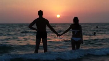 Sahilde iki siluet. günbatımı ışığı.