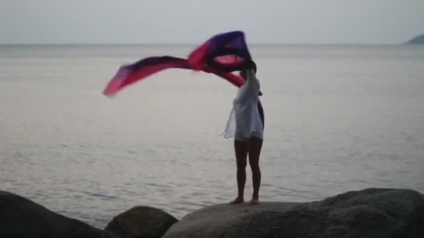 Beautiful young woman on beach with scarf — Stock Video