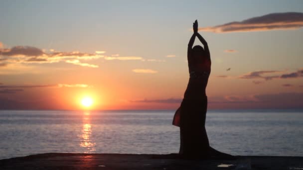 Ευτυχισμένη γυναίκα, χορός στην παραλία στο ηλιοβασίλεμα με φόντο της θάλασσας — Αρχείο Βίντεο