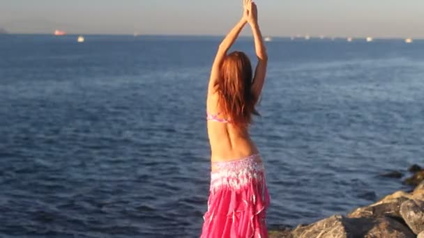 Mulher feliz dançando na praia ao pôr do sol com fundo do mar — Vídeo de Stock