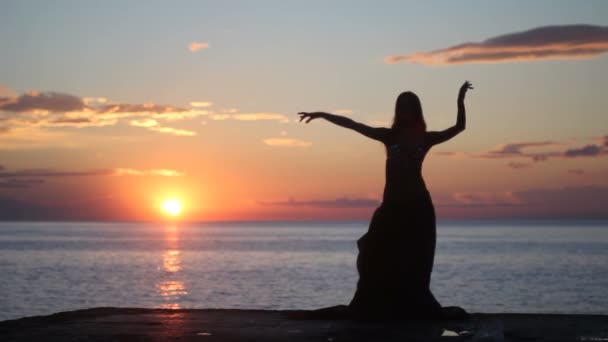 Glückliche Frau tanzt am Strand bei Sonnenuntergang mit Meereshintergrund — Stockvideo