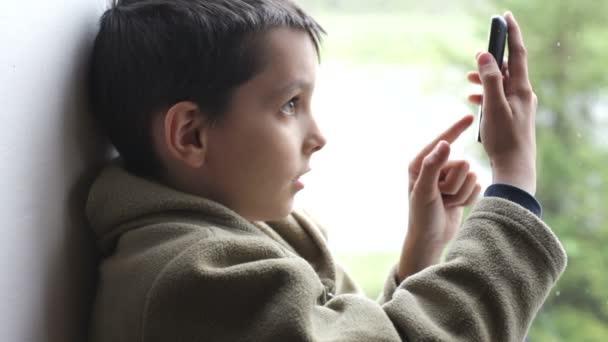 Niño usando un teléfono móvil — Vídeos de Stock