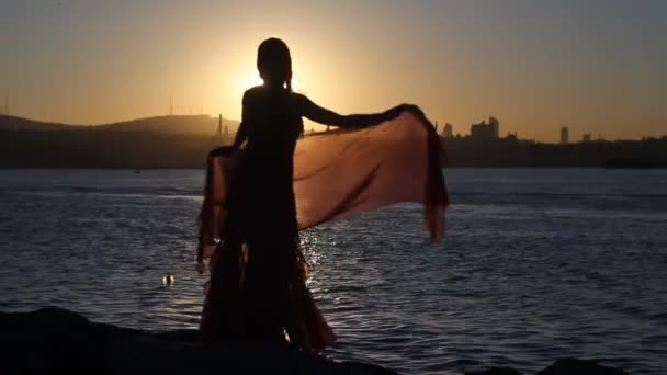 Gelukkige vrouw dansen op het strand bij zonsondergang met zee achtergrond — Stockvideo