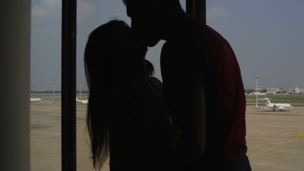 Silueta dvojice milenců, u okna na letišti — Stock video