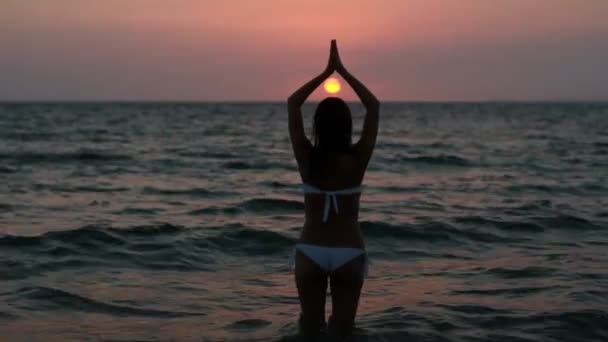 Silhouette egy nő jóga a tenger a sunset. — Stock videók