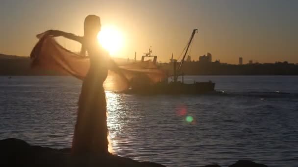 Gelukkige vrouw dansen op het strand bij zonsondergang met zee achtergrond — Stockvideo