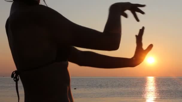 Glad kvinna dansar på stranden vid solnedgången med havet bakgrund — Stockvideo