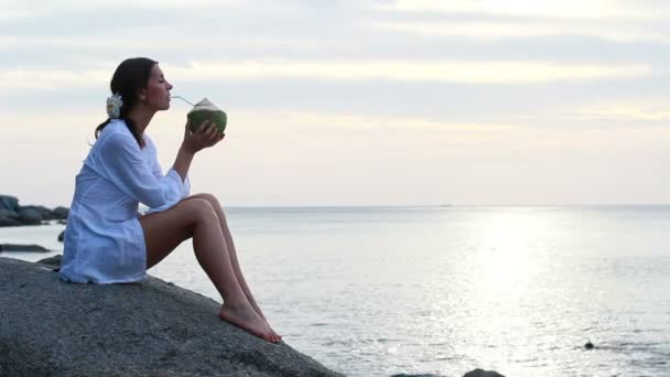 Jonge vrouw met kokos op het strand — Stockvideo