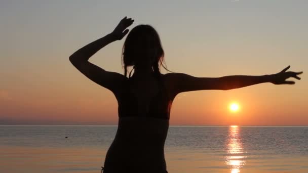 夕暮れの海の背景、ビーチの上で踊って幸せな女 — ストック動画