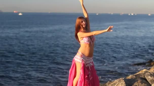 Mulher feliz dançando na praia ao pôr do sol com fundo do mar — Vídeo de Stock