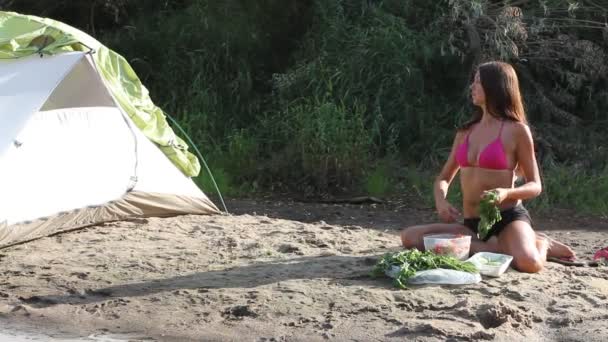 Chica haciendo ensalada en el campamento — Vídeo de stock