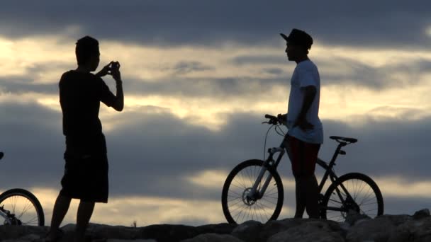 日の出でバイクに乗る人シルエット — ストック動画