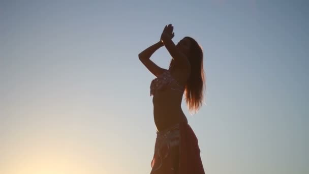 Femme heureuse dansant sur la plage au coucher du soleil avec fond de mer — Video