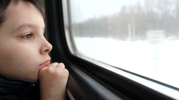 Boy looks out train window — Stock Video