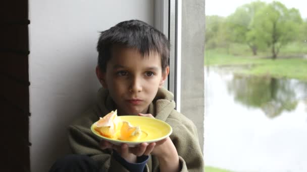 Boy eet een oranje — Stockvideo